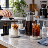 Kaffeekonzentrat in einer Glasflasche neben Cold Brew und Espresso