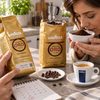 Lavazza Kaffeepackung mit aufgedrucktem Mindesthaltbarkeitsdatum neben Espressotasse
