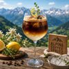 Alpine Coffee Spritz mit Espresso, Mineralwasser, Traubensaft, Eiswürfeln und frischem Thymian im Sommerglas.