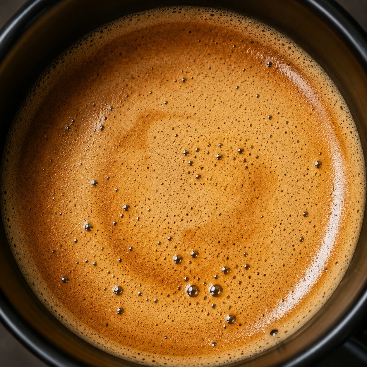 Goldbraune Kaffee Crema auf frisch gebrühtem Café Crema aus dem Vollautomaten mit dichter Schaumkrone.