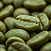 Verschiedene Kaffeebohnen neben Espressotasse und Kaffeemühle als Übersicht zu Arten und Röstungen