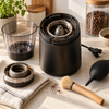 Kaffeemühle wird mit Pinsel von Kaffeeöl und Pulverresten gereinigt für frischen Kaffeegeschmack