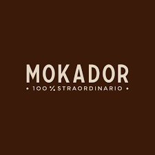 Mokador Kaffee Sortiment: Italienische Kaffeebohnen, E.S.E. Pads und Kapseln vor klassischem Espresso-Hintergrund.