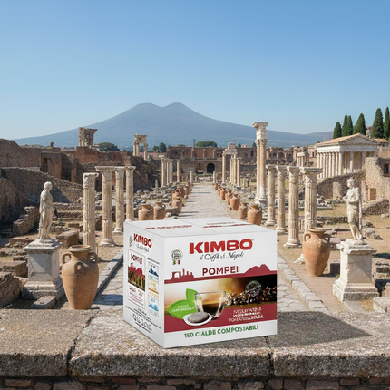 Einzelnes biologisch abbaubares ESE Pad von Kimbo Pompei neben einer Tasse frischem Espresso.