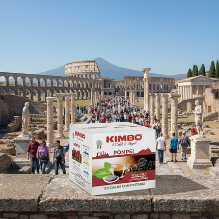 Eine dampfende Tasse Kimbo Pompei Kaffee auf einem Küchentisch, daneben die 150er Packung Pads.